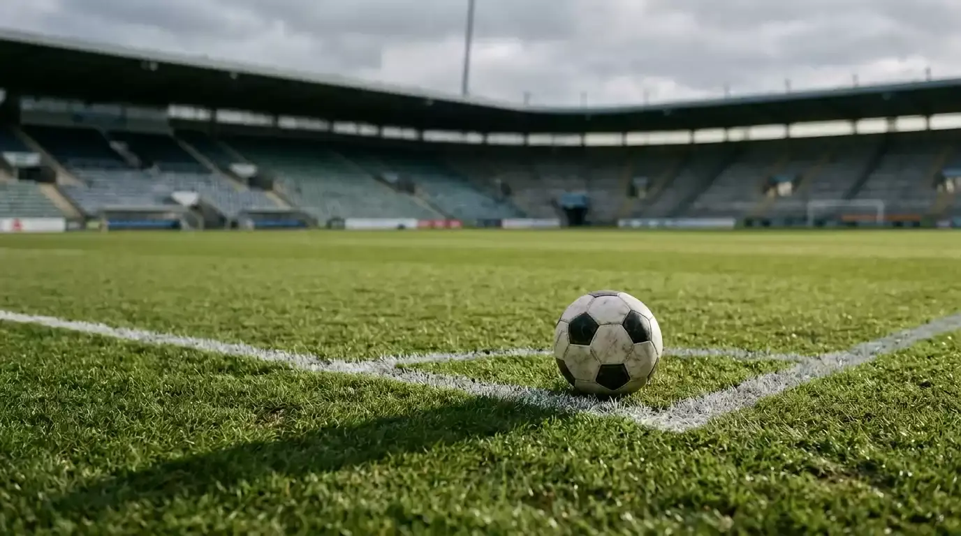 Fodbold i skygge på pitch med overskyet vejr