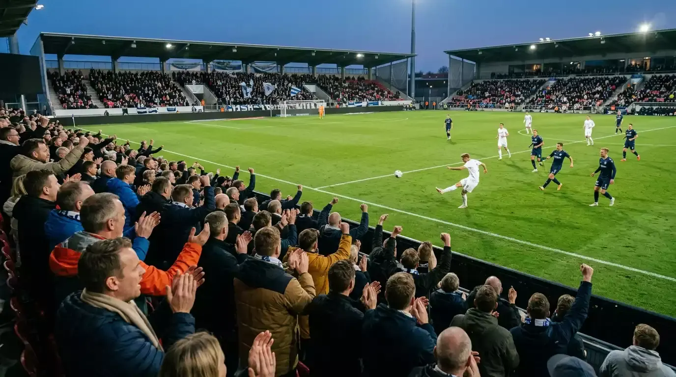 Dansk Superliga-fodboldkamp på en fyldt tribune i tidlig aften